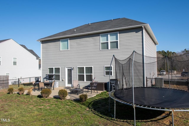 back of house featuring central AC, a patio, a lawn, and a trampoline