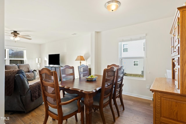 dining room with ceiling fan and dark hardwood / wood-style flooring