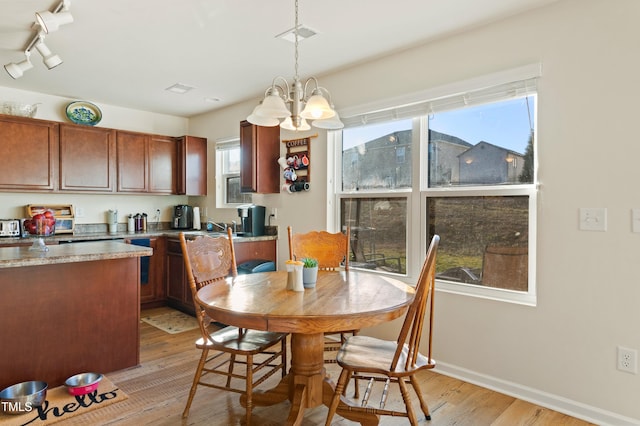 dining area with a chandelier and light hardwood / wood-style floors