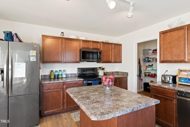 kitchen featuring light wood-type flooring, appliances with stainless steel finishes, and a kitchen island