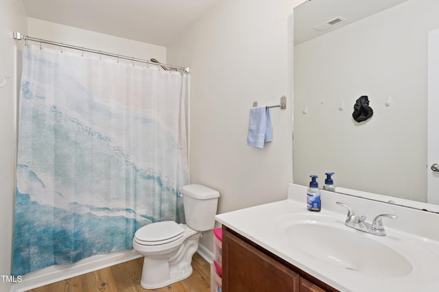 full bathroom featuring hardwood / wood-style floors, toilet, vanity, and shower / tub combo