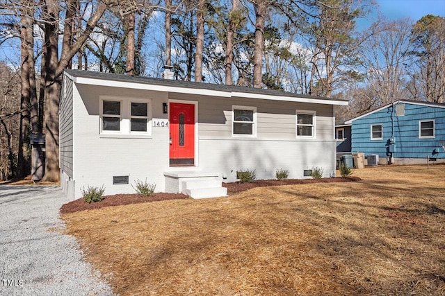 view of front facade with cooling unit and a front lawn