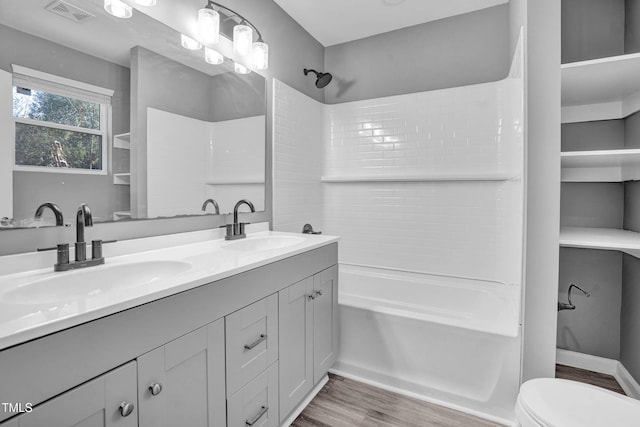 full bathroom with toilet, shower / bath combination, vanity, and hardwood / wood-style flooring