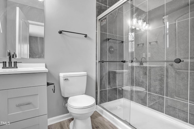 bathroom featuring toilet, walk in shower, hardwood / wood-style floors, and vanity