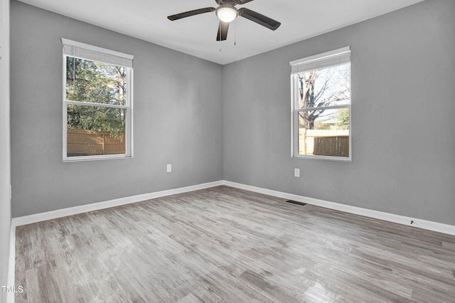 unfurnished room with ceiling fan, plenty of natural light, and light hardwood / wood-style flooring