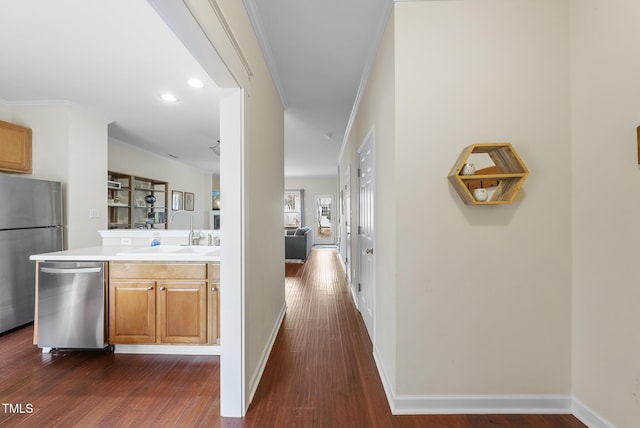 corridor with ornamental molding, dark hardwood / wood-style floors, and sink