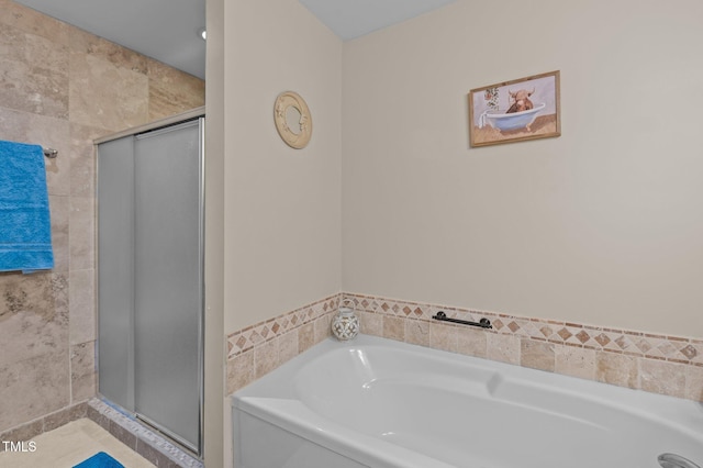 bathroom with shower with separate bathtub, tile walls, and tile patterned floors