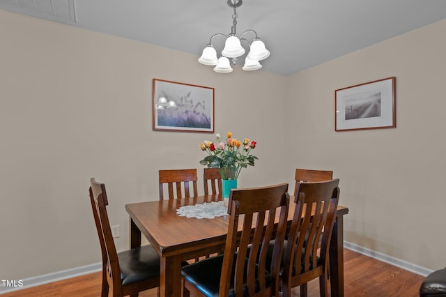 dining room with an inviting chandelier and wood-type flooring