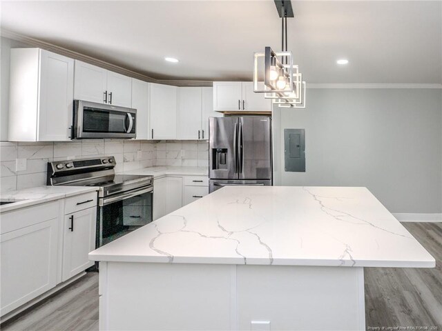 kitchen featuring a kitchen island, hanging light fixtures, light stone countertops, appliances with stainless steel finishes, and white cabinets