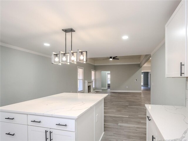 kitchen with decorative light fixtures, white cabinets, and ceiling fan