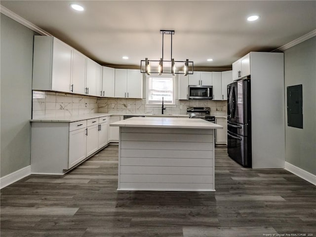 kitchen with appliances with stainless steel finishes, white cabinets, hanging light fixtures, and a kitchen island