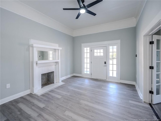 unfurnished living room featuring ceiling fan, wood-type flooring, and ornamental molding