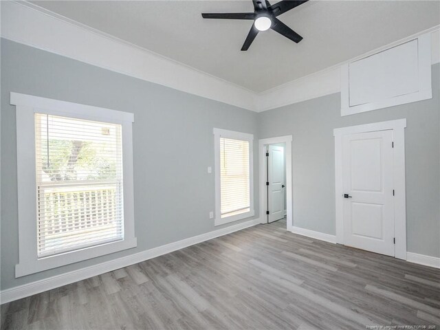 empty room featuring ceiling fan, crown molding, and light hardwood / wood-style floors