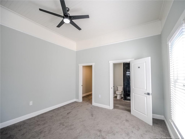 unfurnished bedroom with ceiling fan, crown molding, light carpet, and ensuite bath