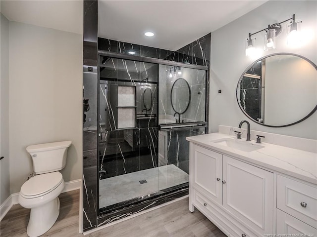 bathroom with toilet, walk in shower, hardwood / wood-style flooring, and vanity