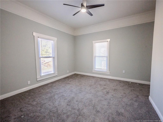 spare room with ceiling fan, ornamental molding, and dark colored carpet