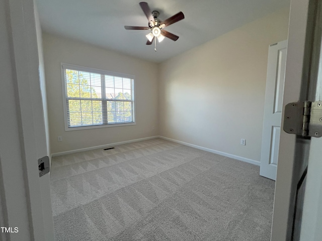 spare room featuring light colored carpet and ceiling fan