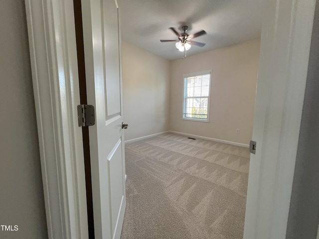 unfurnished room featuring light colored carpet and ceiling fan