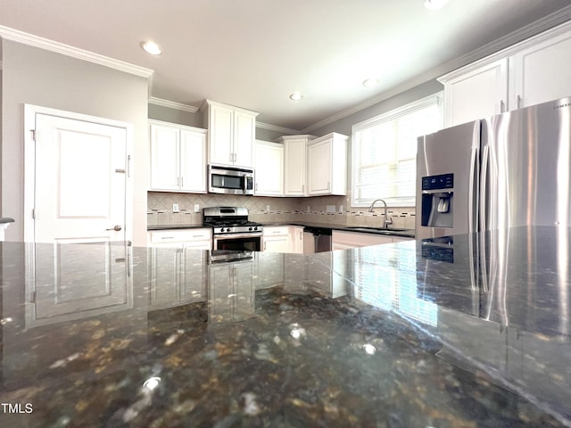 kitchen featuring dark stone countertops, sink, stainless steel appliances, and white cabinets