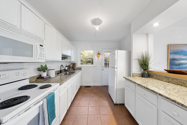 kitchen with sink, light tile patterned flooring, white appliances, and white cabinets