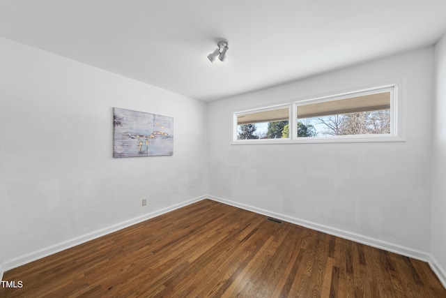 empty room with dark hardwood / wood-style flooring