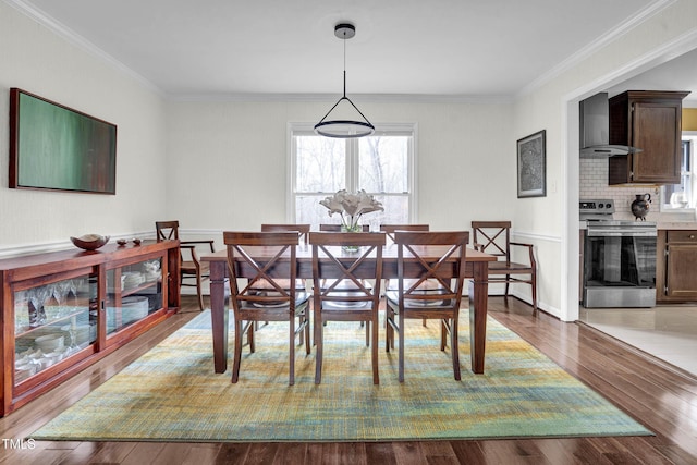 dining room featuring ornamental molding and light wood-type flooring