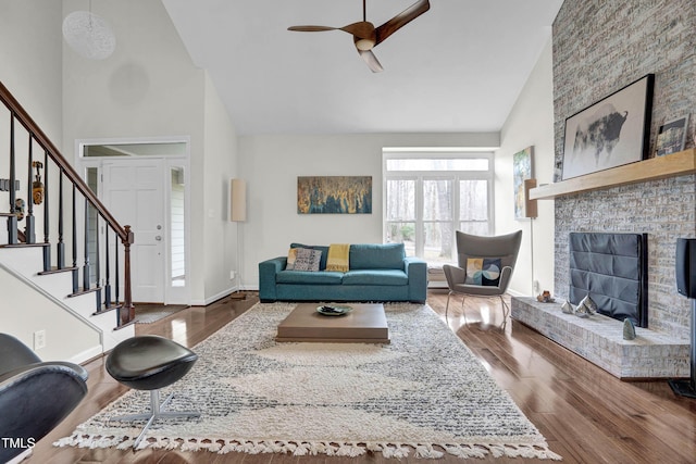 living room featuring baseboards, stairs, high vaulted ceiling, and dark wood-type flooring