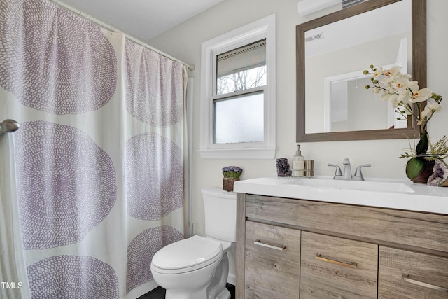 bathroom with toilet, vanity, visible vents, and a shower with curtain