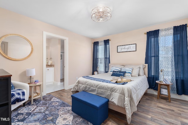 bedroom featuring dark hardwood / wood-style floors and ensuite bath