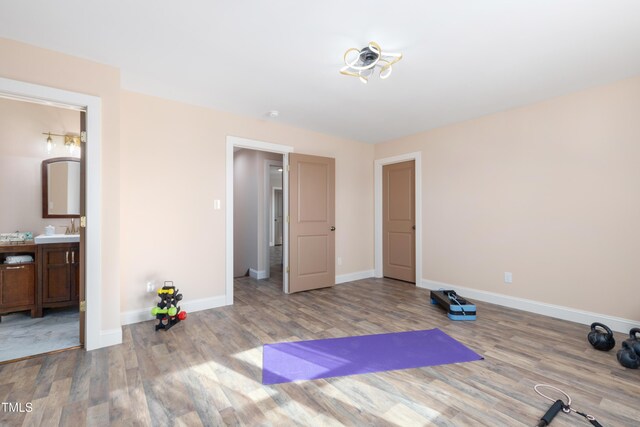 exercise area with sink and light wood-type flooring