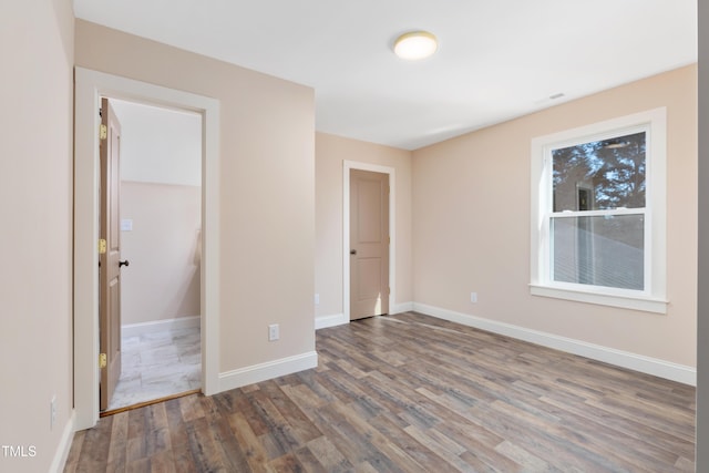 unfurnished bedroom with hardwood / wood-style floors, a closet, and a walk in closet