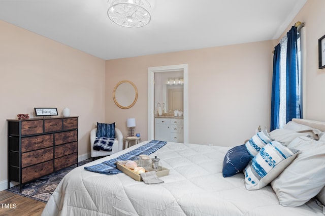 bedroom with hardwood / wood-style floors and ensuite bathroom