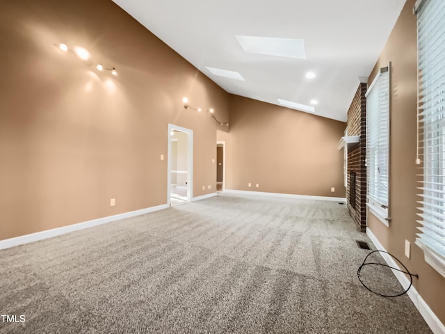 unfurnished living room featuring carpet, a skylight, and high vaulted ceiling