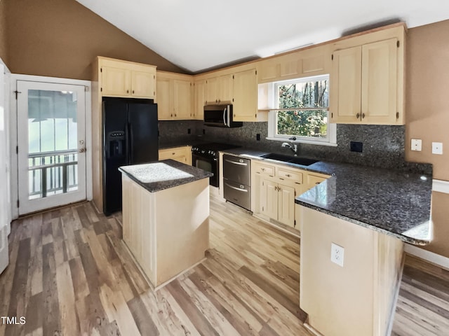 kitchen featuring vaulted ceiling, a center island, black appliances, sink, and light wood-type flooring