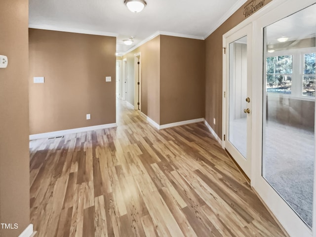 spare room featuring hardwood / wood-style flooring, crown molding, and french doors