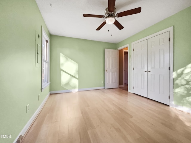 unfurnished bedroom with ceiling fan, light hardwood / wood-style flooring, and a closet