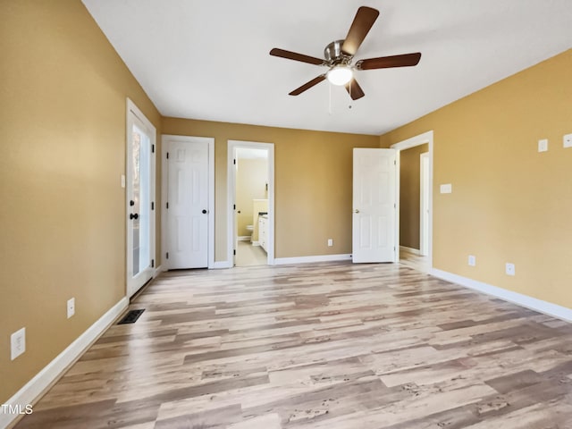 unfurnished bedroom with ceiling fan, ensuite bathroom, and light wood-type flooring