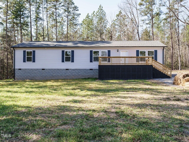 rear view of property with a wooden deck and a lawn