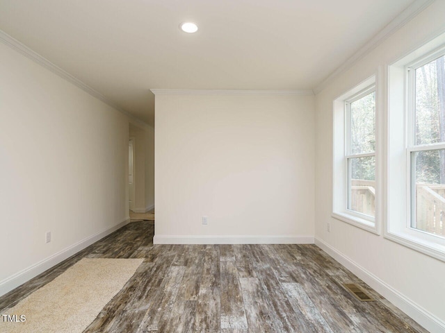 empty room featuring crown molding, dark hardwood / wood-style floors, and a healthy amount of sunlight