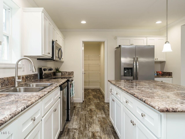 kitchen with dark hardwood / wood-style floors, pendant lighting, white cabinetry, sink, and stainless steel appliances