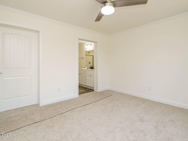 unfurnished bedroom with ornamental molding, ensuite bathroom, ceiling fan, and carpet flooring