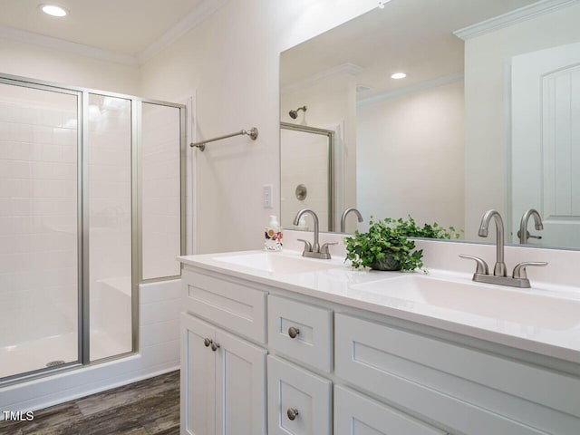 bathroom with an enclosed shower, ornamental molding, hardwood / wood-style floors, and vanity