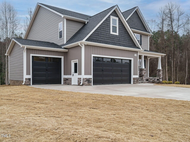 craftsman-style home featuring a porch, a garage, and a front lawn