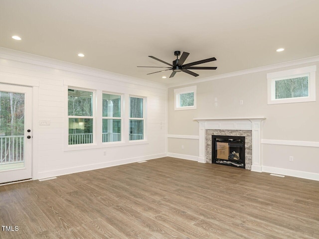 unfurnished living room featuring ornamental molding, wood-type flooring, and plenty of natural light