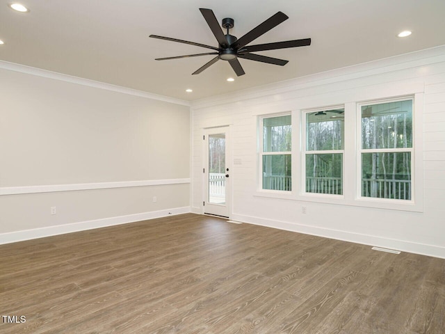 empty room featuring dark wood-type flooring, ceiling fan, and ornamental molding