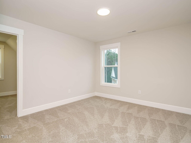 spare room with visible vents, baseboards, and carpet