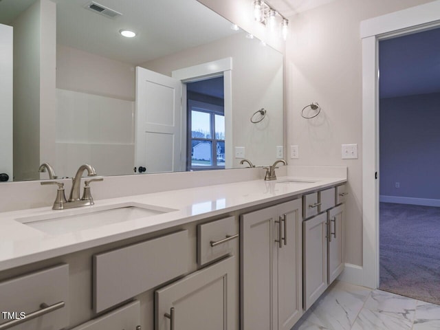 bathroom with a sink, visible vents, marble finish floor, and double vanity