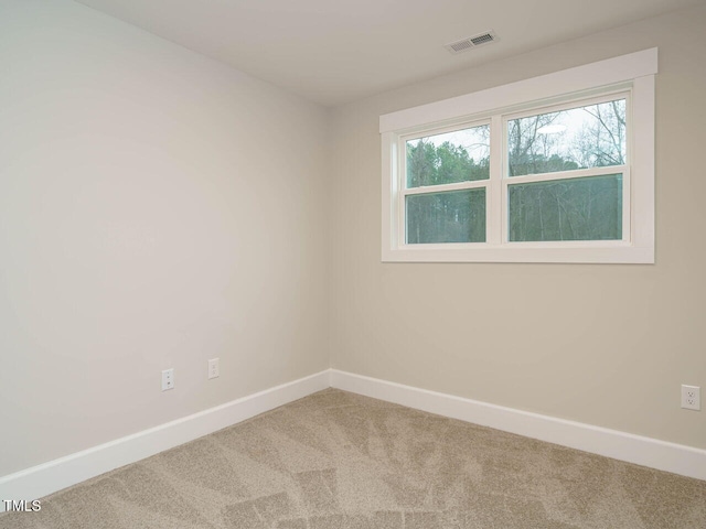 empty room with visible vents, carpet, and baseboards