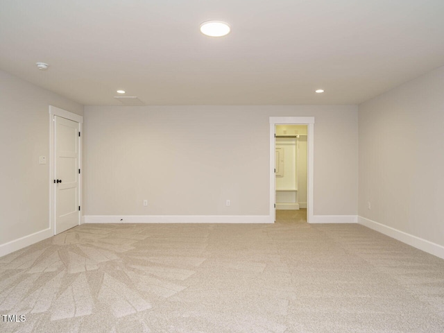 empty room with recessed lighting, light colored carpet, and baseboards