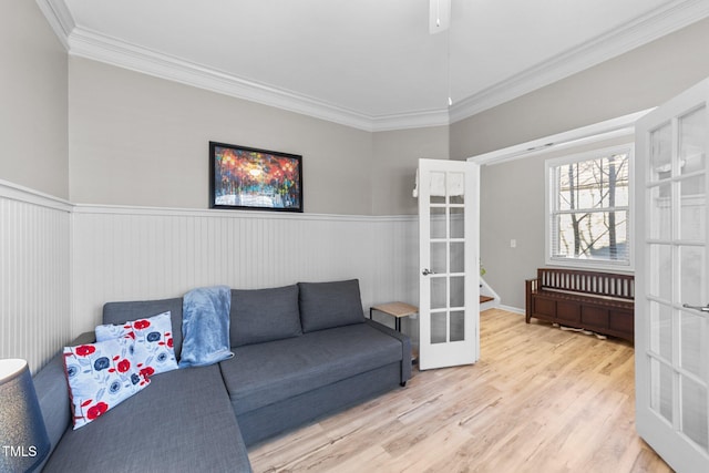 living room featuring light hardwood / wood-style floors, ornamental molding, and french doors